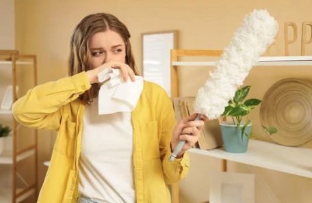 Moteris čiaudi valydama dulkes – galimi alergijos namų dulkių erkėms simptomai