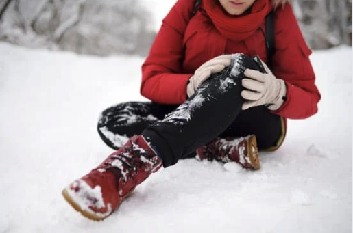 Žmogus paslydęs ant sniego laiko sužeistą koją – galima žiemos trauma