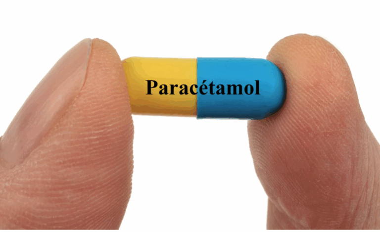 Paracetamolio tabletė tarp pirštų